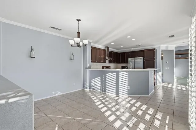 a living room with kitchen island furniture and a chandelier