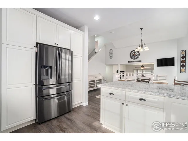 a kitchen with stainless steel appliances a refrigerator a sink a stove a dining table and chairs