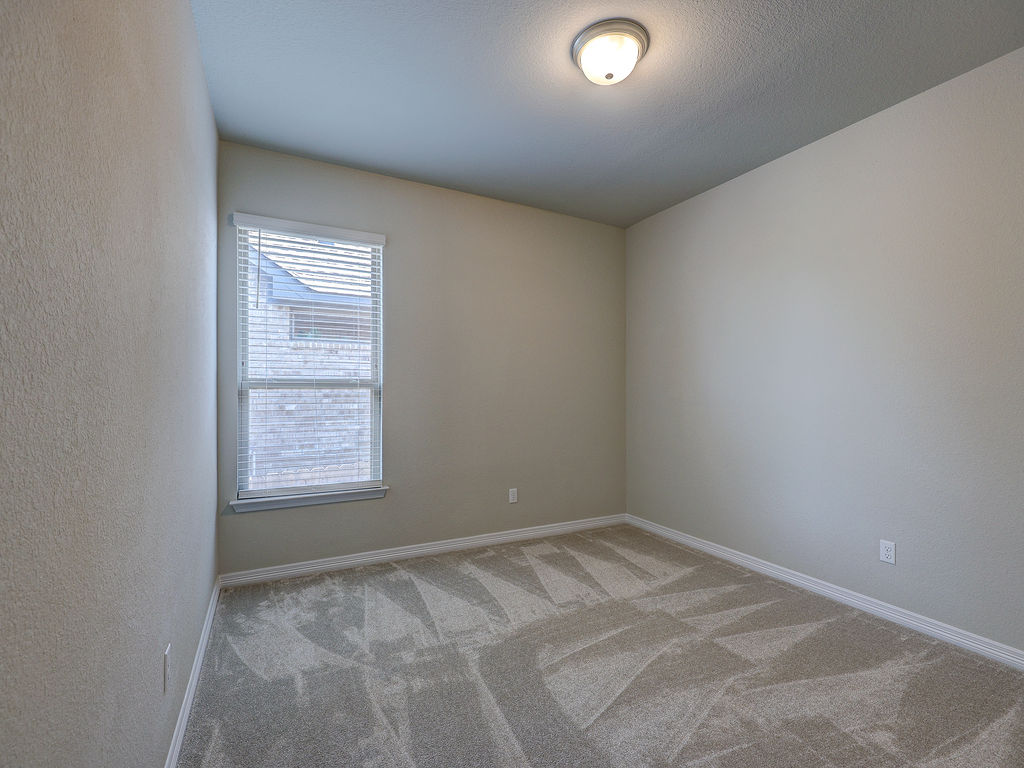 229 Heartleaf Road San Marcos, TX 78666 - Photo 35 of 40 A well-lit bedroom features plush carpet and a single window for natural light.