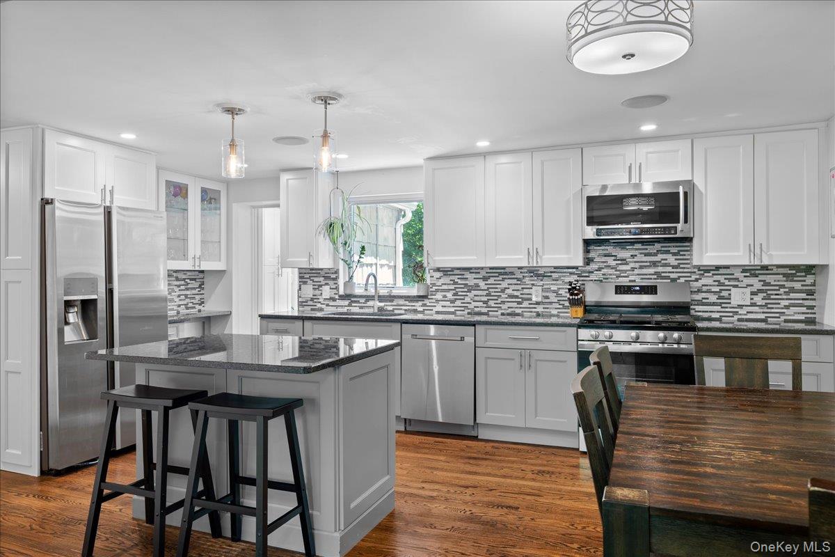 105 High St Extension Mount Kisco, NY 10549 - Photo 18 of 38 a kitchen with stainless steel appliances granite countertop a stove top oven a sink refrigerator and cabinets
