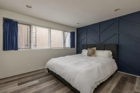 a large bed sitting in a bedroom next to a window