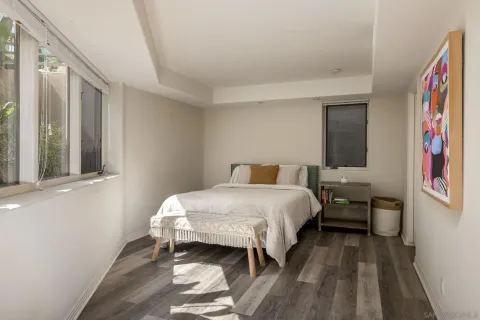 a bedroom with a bed and wooden floor