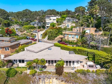 a view of a building with a yard and sitting area