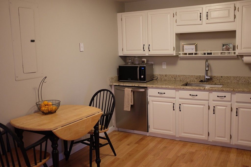 39 Parlin Street, Unit 605 Everett, MA 02149 - Photo 11 of 21 a kitchen with stainless steel appliances granite countertop a sink a stove a dining table and chairs