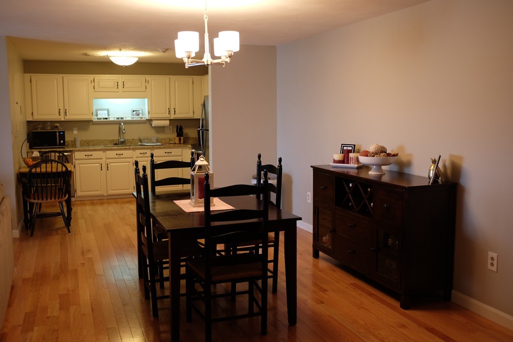 39 Parlin Street, Unit 605 Everett, MA 02149 - Photo 12 of 21 a kitchen with a dining table chairs and wooden floor