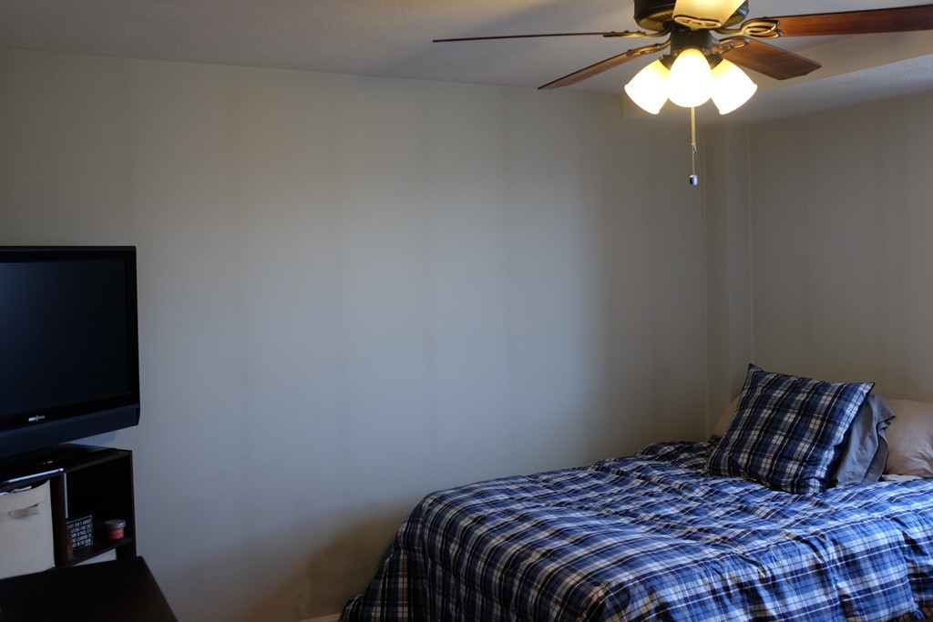39 Parlin Street, Unit 605 Everett, MA 02149 - Photo 16 of 21 a bedroom with a bed and a chandelier