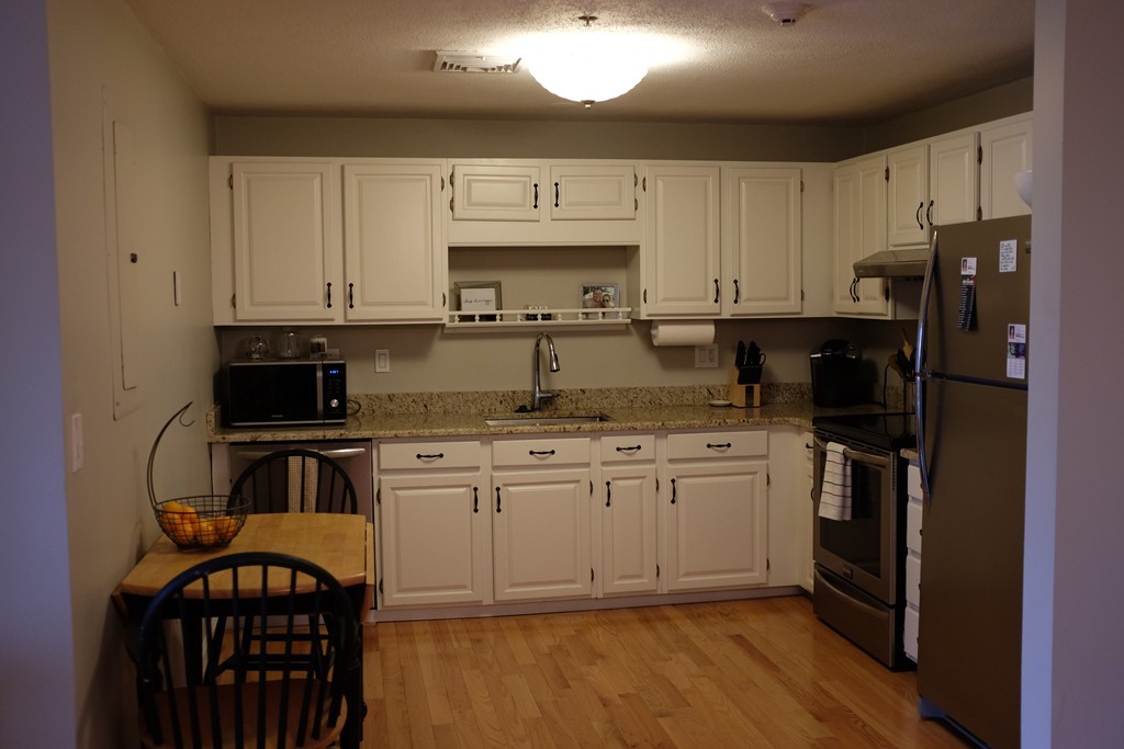 39 Parlin Street, Unit 605 Everett, MA 02149 - Photo 9 of 21 a kitchen with granite countertop a refrigerator stove top oven and sink