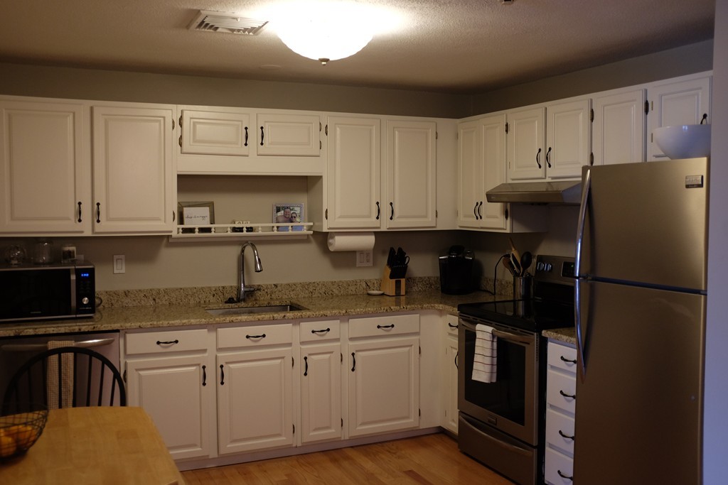 39 Parlin Street, Unit 605 Everett, MA 02149 - Photo 10 of 21 a kitchen with granite countertop a refrigerator stove top oven and sink