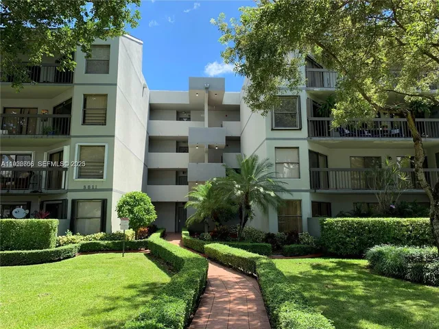 a front view of a residential apartment building with a yard