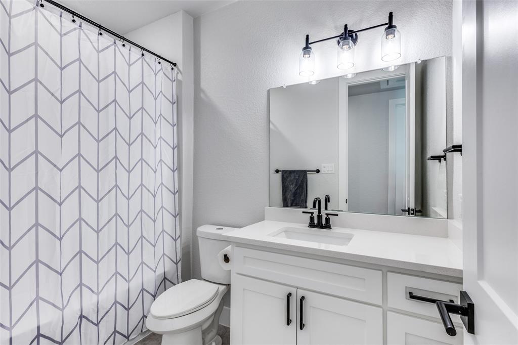2255 County Road 377 Van Alstyne, TX 75495 - Photo 25 of 35 a bathroom with a sink a toilet and shower curtain