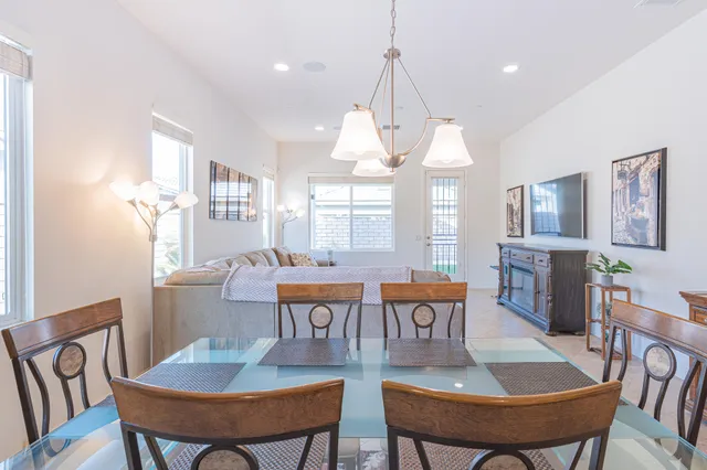 a dining room with furniture a chandelier and wooden floor