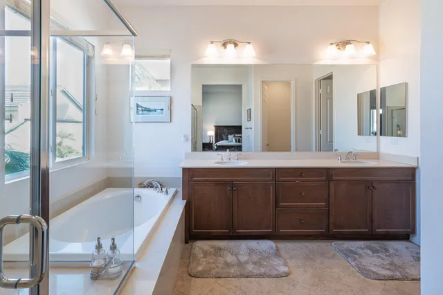 a spacious bathroom with a tub sink and mirror