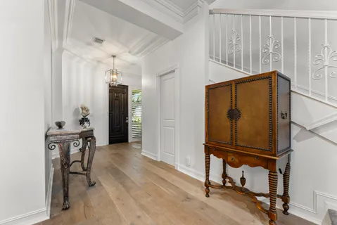 a living room with stainless steel appliances kitchen island granite countertop a refrigerator a stove a sink a dining table and chairs with wooden floor