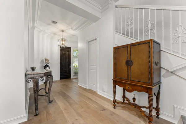a living room with stainless steel appliances kitchen island granite countertop a refrigerator a stove a sink a dining table and chairs with wooden floor