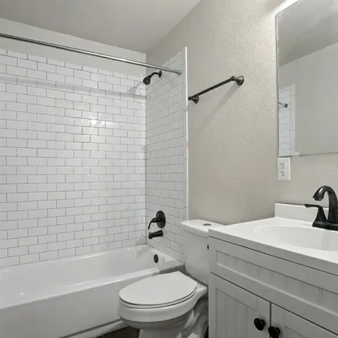 a bathroom with a toilet a sink a mirror and shower