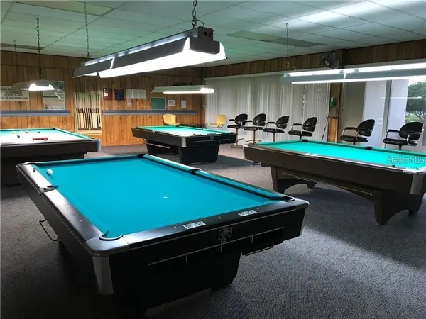 a room with pool table table soccer and windows