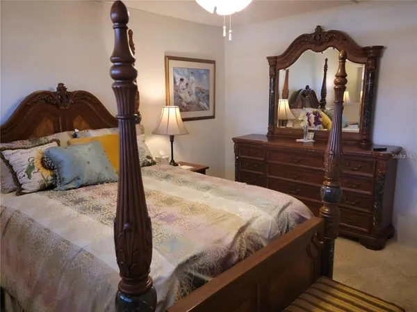 a bedroom with a bed and a dresser with mirror