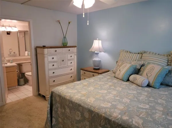 a bedroom with a bed and a lamp on dresser