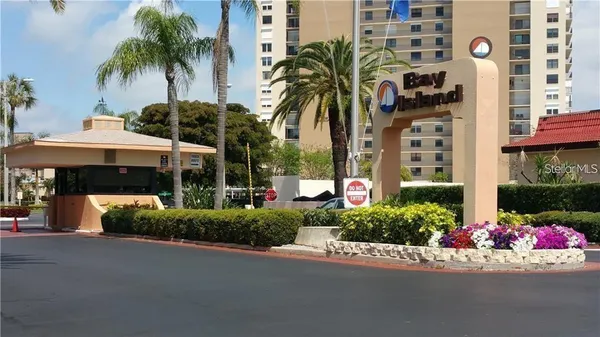 a front view of multi story residential apartment building with yard and outdoor seating