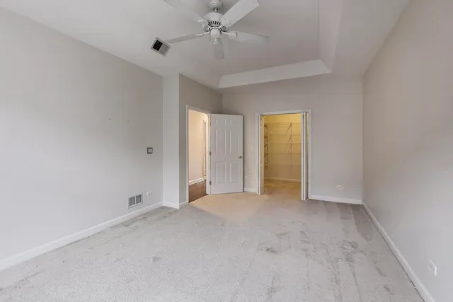 an empty room with fan and entrance