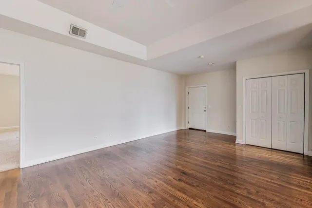 a view of an empty room with wooden floor