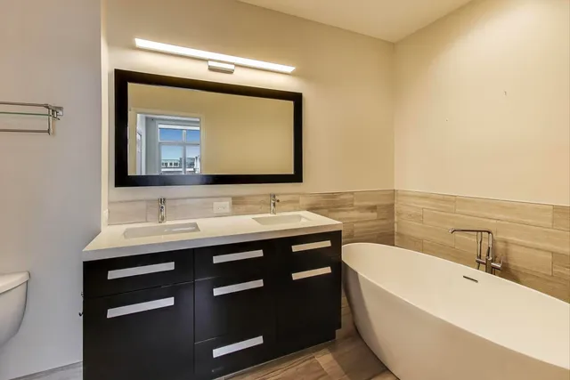 a bathroom with a tub sink and mirror