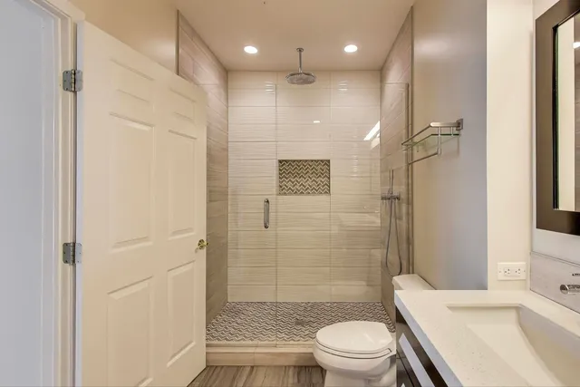 a bathroom with a sink a toilet and shower