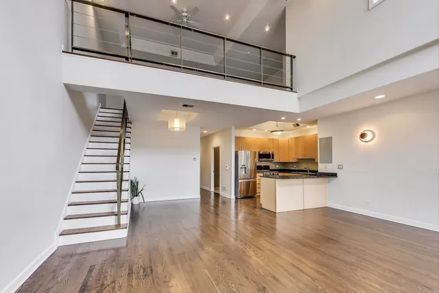 a kitchen with stainless steel appliances wooden floor and chairs