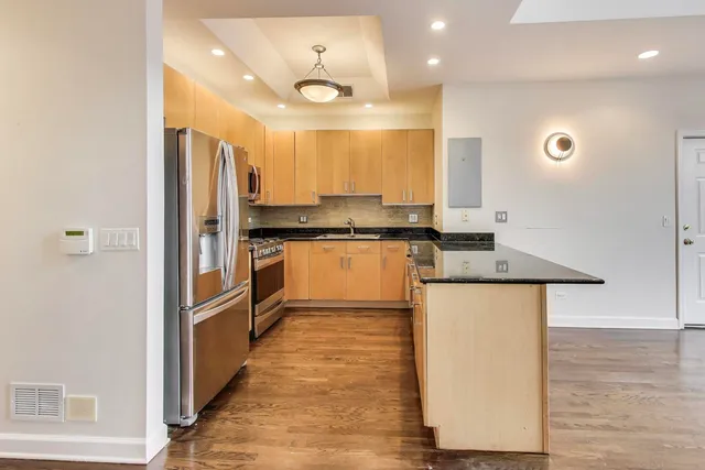 a kitchen with stainless steel appliances granite countertop a stove a sink and a refrigerator