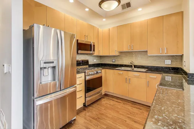 a kitchen with stainless steel appliances a refrigerator sink and microwave