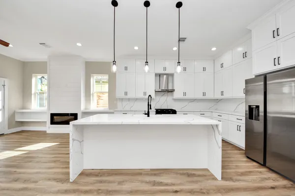 a kitchen with kitchen island a sink stainless steel appliances and cabinets