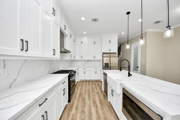a kitchen with a sink a counter space stainless steel appliances and cabinets