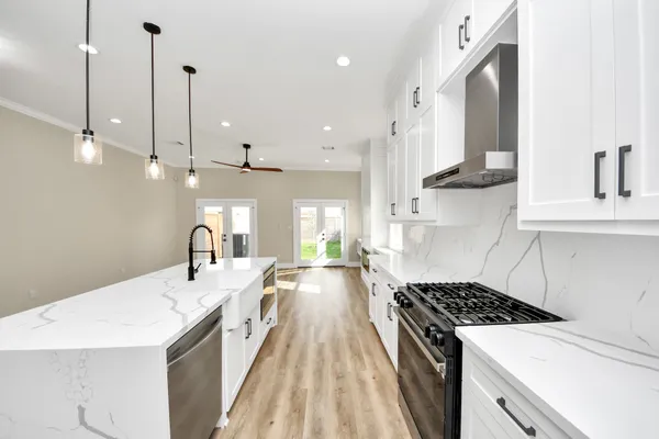 a view of kitchen with kitchen island white cabinets and stainless steel appliances