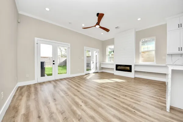 a view of a kitchen with kitchen island a refrigerator wooden floor and a fireplace