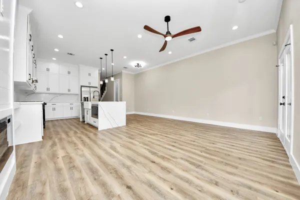 a view of an empty room with a window and wooden floor
