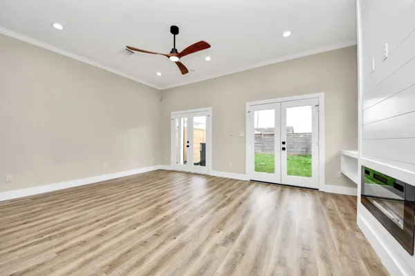 a view of a hallway with wooden floor and a bathroom