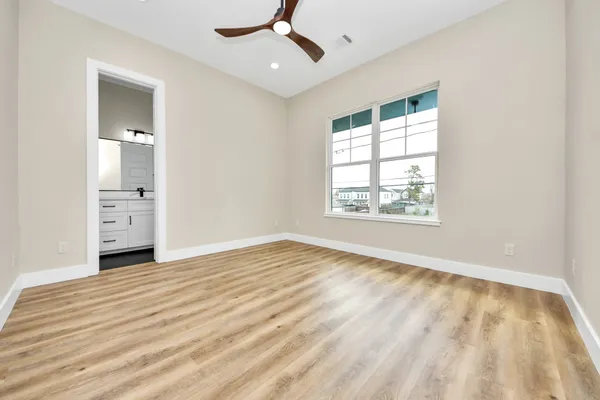 a view of a livingroom with wooden floor and a ceiling fan