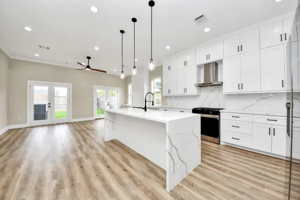 a large kitchen with kitchen island a sink stainless steel appliances and cabinets