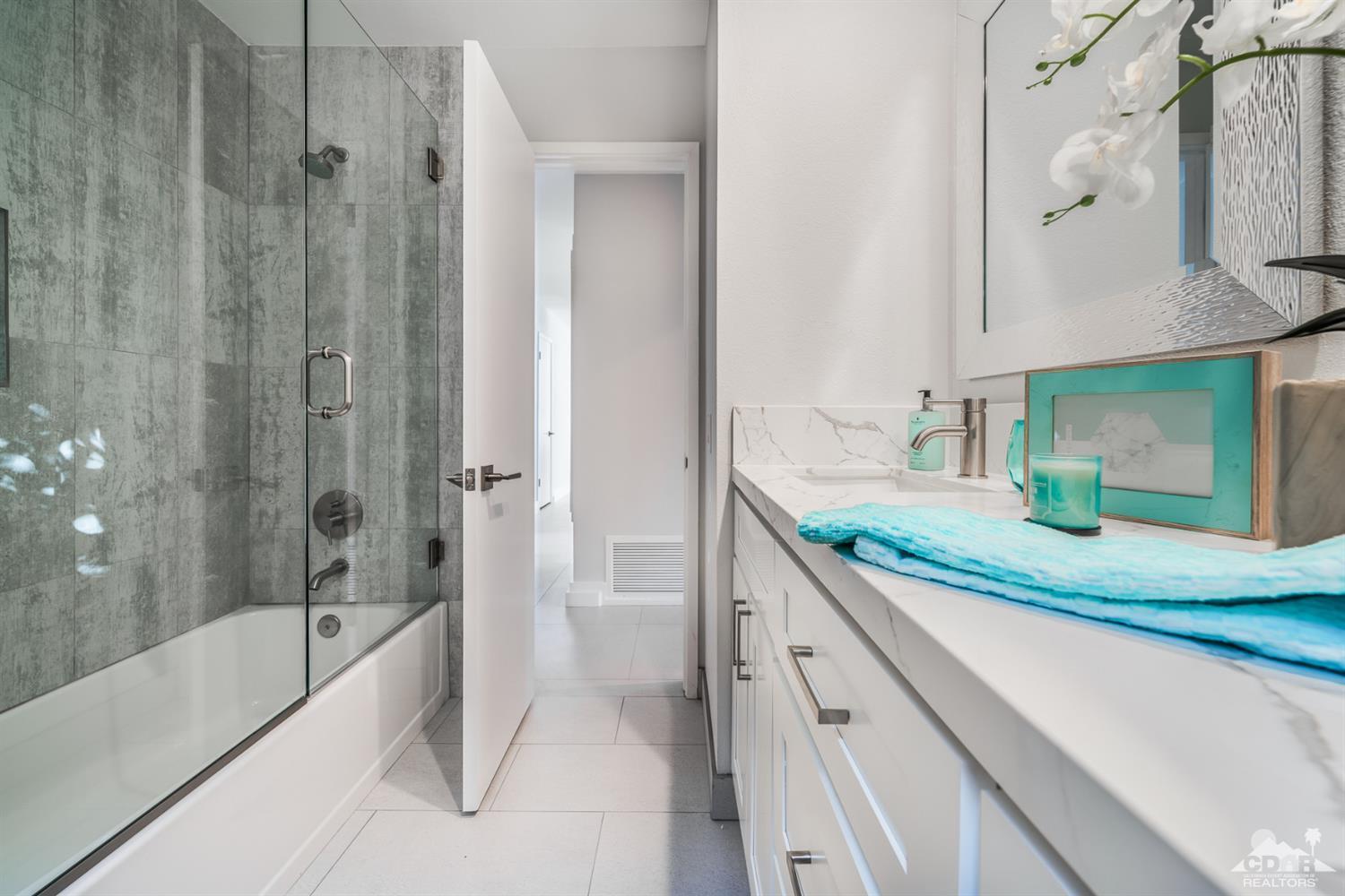 72845 Haystack Road Palm Desert, CA 92260 - Photo 30 of 39 a bathroom with a granite countertop sink mirror and a bathtub