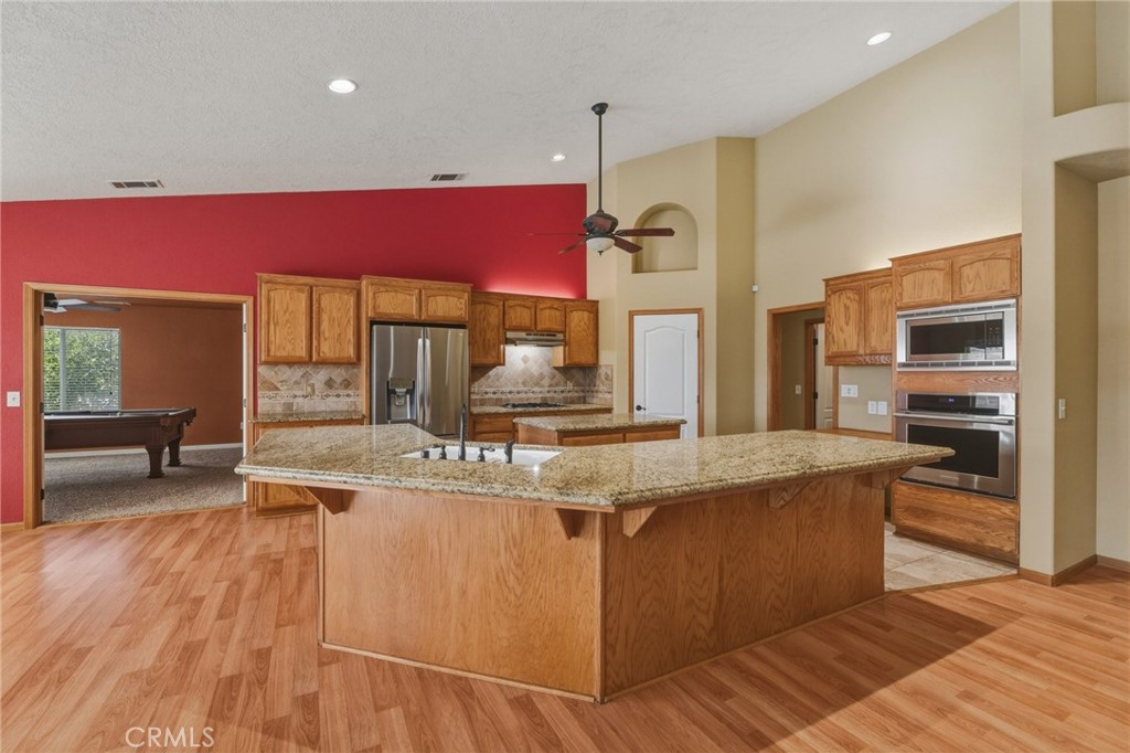 19501 Kinai Road Apple Valley, CA 92307 - Photo 14 of 49 a view of a kitchen with kitchen island a counter top space a sink and cabinets