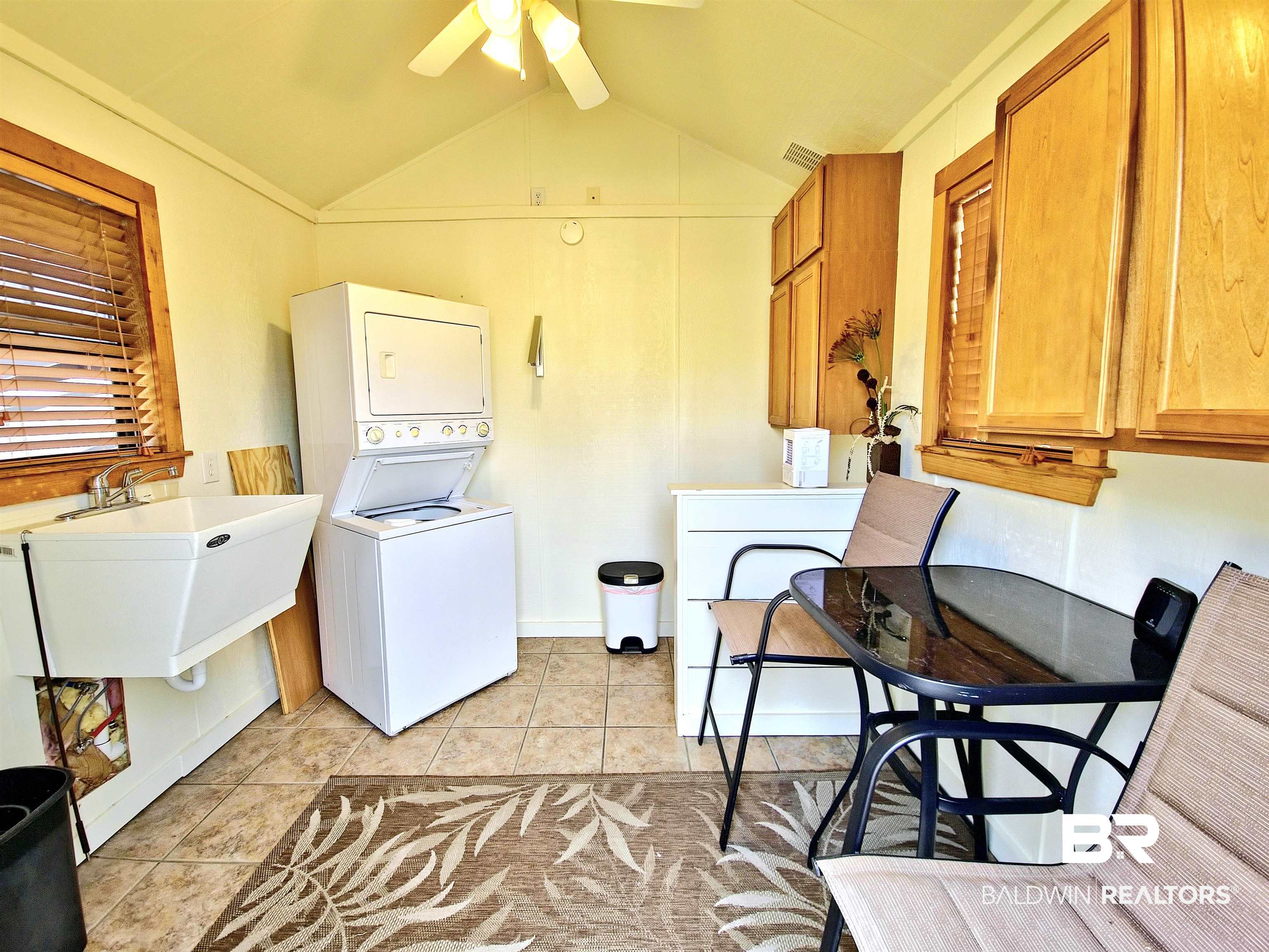 4650 Griffith Marina Road, Unit 12 Orange Beach, AL 36561 - Photo 10 of 34 Laundry area featuring lofted ceiling, stacked washer / dryer, light tile patterned flooring, and ceiling fan
