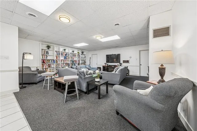 a living room with furniture wooden floor and a large window