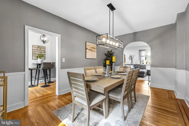 a view of a dining room with furniture a chandelier and wooden floor