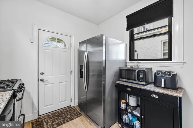 a kitchen with a refrigerator and a stove top oven