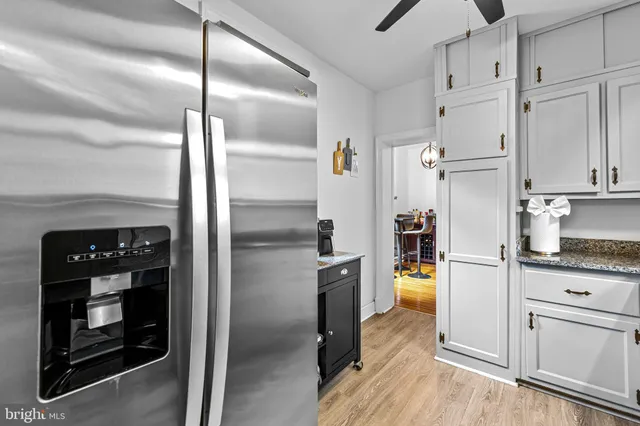 a kitchen with stainless steel appliances a refrigerator a stove and white cabinets