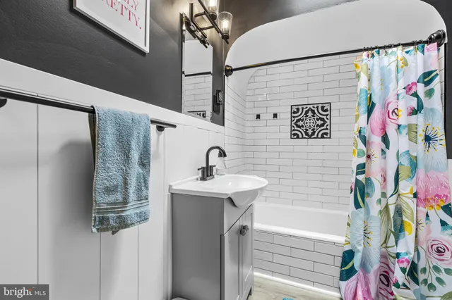 a bathroom with a sink a mirror and shower curtain