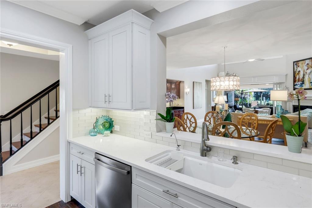 11426 Quail Village Way Naples, FL 34119 - Photo 13 of 46 a kitchen with stainless steel appliances granite countertop a sink and a white cabinets
