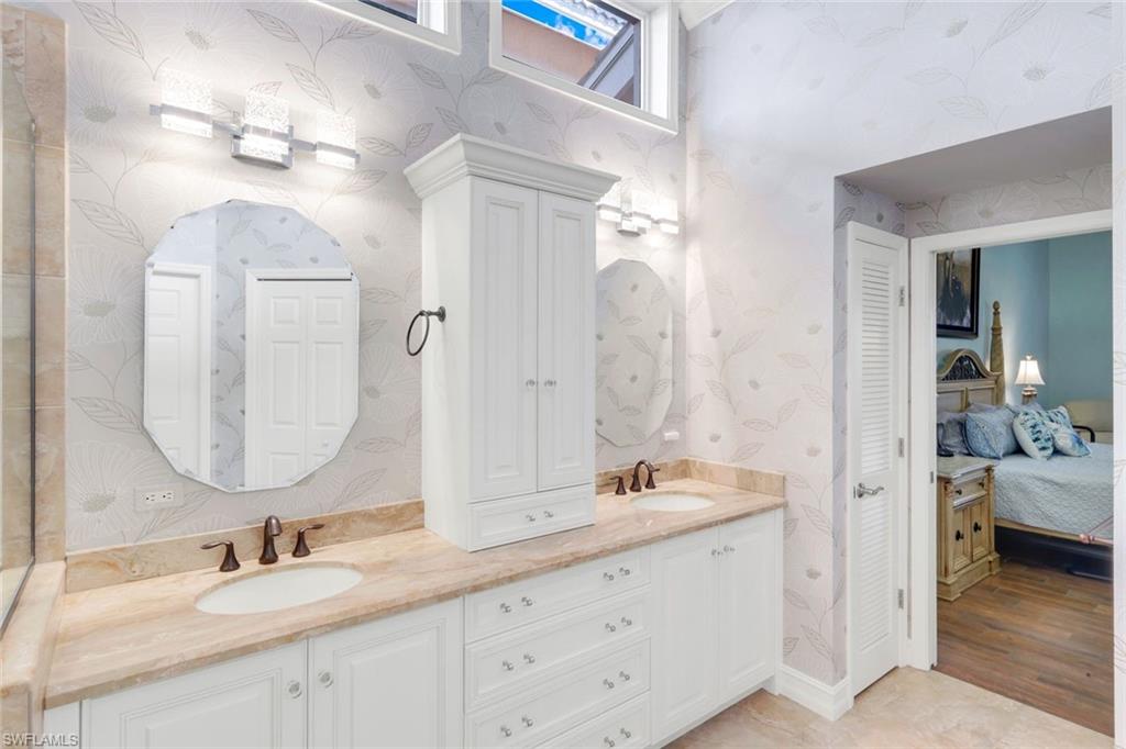 11426 Quail Village Way Naples, FL 34119 - Photo 17 of 46 a en suite bathroom with a double vanity sink and a mirror