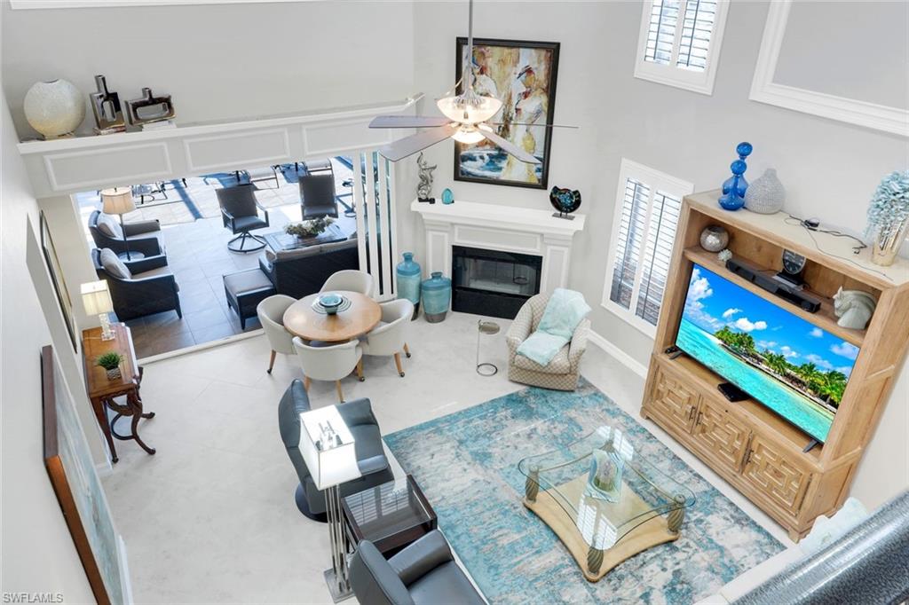 11426 Quail Village Way Naples, FL 34119 - Photo 20 of 46 a living room with furniture and a fireplace