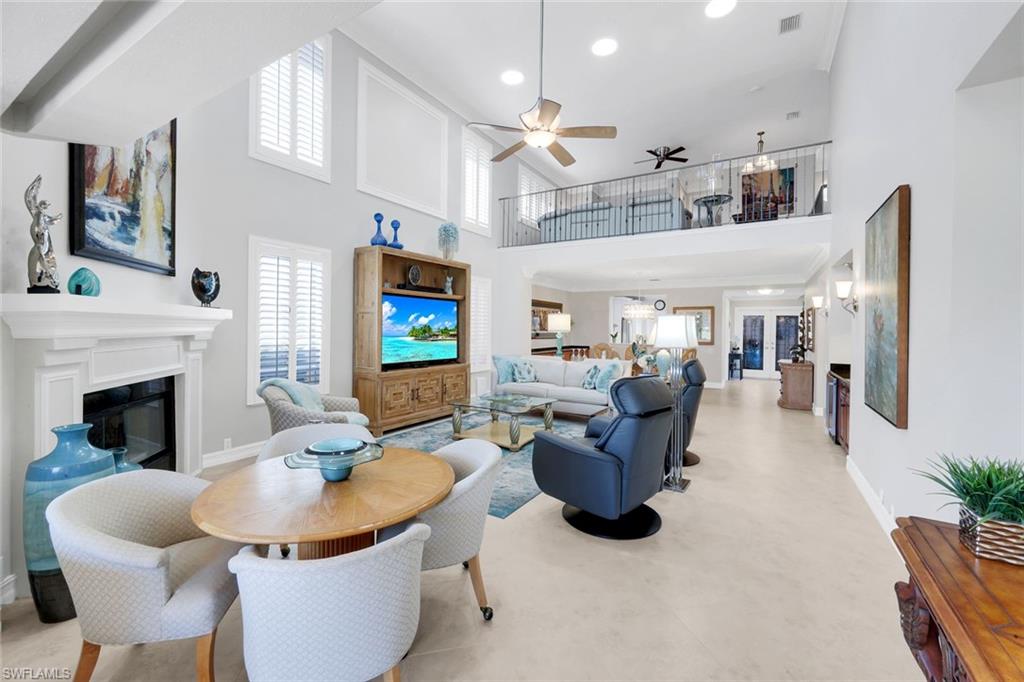 11426 Quail Village Way Naples, FL 34119 - Photo 2 of 46 a living room with furniture a fireplace and a flat screen tv